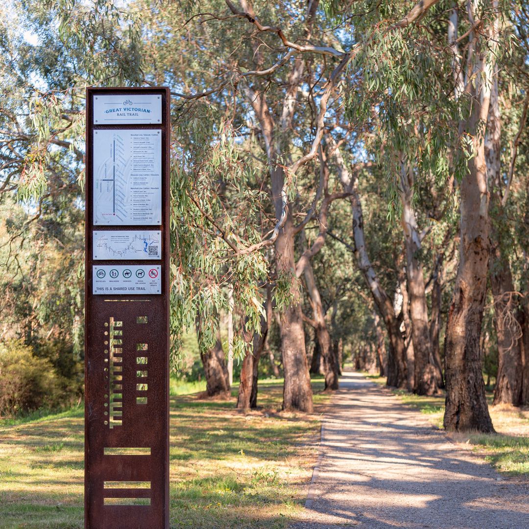 Signpost, gravel trail and gum trees on the Great Victorian Rail Trail